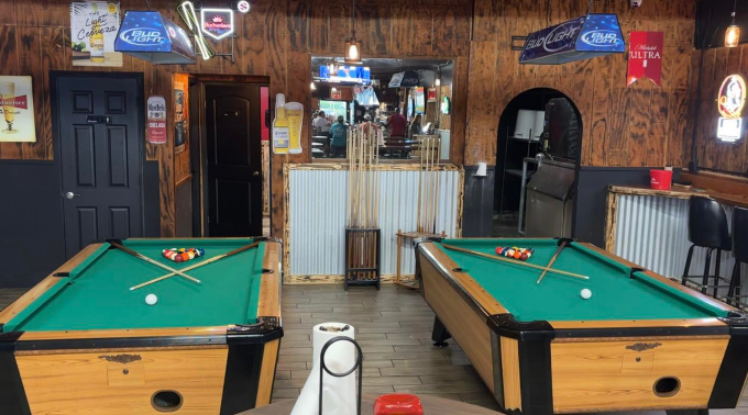 Pool tables under neon beer signs